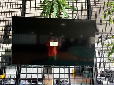 un écran de télévision sur lequel on voit une personne tenant une pancarte