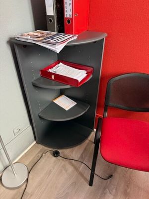 a red chair next to a black desk with a red chair next to it