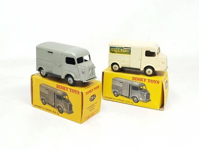 deux camions miniatures posés sur des cartons, sur une surface blanche