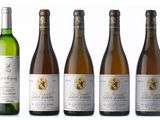 several bottles of wine are lined up on a white surface