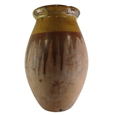 un vase brun posé sur une surface blanche
