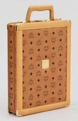 une image représentant une valise marron ornée d'un motif représentant un crâne et des os croisés