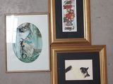 trois tableaux encadrés sur le mur d'une pièce