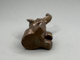 une petite sculpture en bronze représentant une girafe posée sur une surface blanche