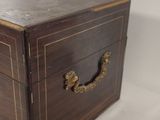 a small wooden box with brass handles on a white surface