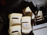 plusieurs chaises et une table dans une pièce où il y a beaucoup de cartons par terre