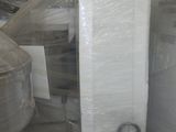 many rolls of plastic wrapped around a toilet in a warehouse
