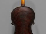 an old violin with a wooden back and bow on a gray background
