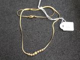 gros plan sur un collier en or portant une étiquette