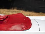a close up of a red leather seat on a white car