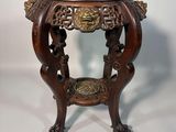 une image représentant une petite table surmontée d'une tête de lion