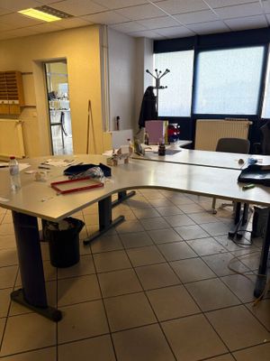 une pièce avec une table, des chaises et un ordinateur portable posé dessus