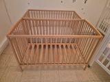 un lit de bébé avec un cadre en bois dans une chambre