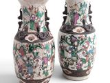 pair of chinese vases with floral designs on them against a white background