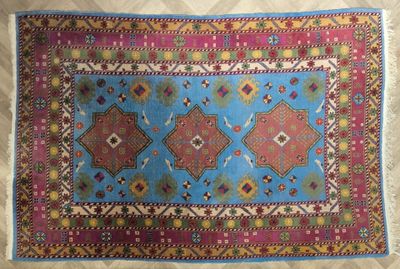 un tapis bleu et rose posé sur un parquet