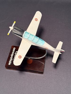un petit avion en jouet posé sur un socle en bois