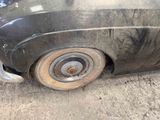 a dirty car that is parked on the side of the road