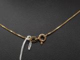 a gold necklace with a knot and a white thread
