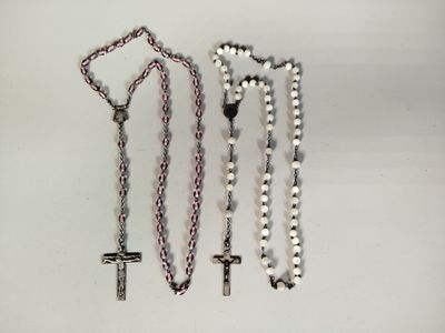 trois grains de chapelet et une croix sur un fond blanc