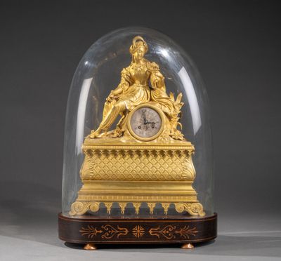 une horloge en or sous un dôme de verre sur une table