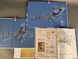 three books with drawings of people on them sitting on top of a table