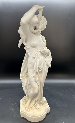 une image représentant une statue blanche d'une femme tenant une fleur