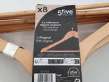 three wooden hangers on a rack with a tag on them