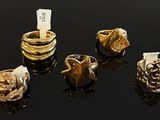 several gold rings are displayed on a black surface with a price tag