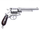 un vieux revolver avec un manche en bois sur fond blanc