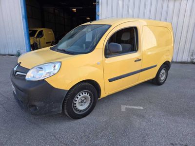 the small yellow van is parked in front of a building