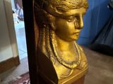 a gold bust of a woman sitting on a table