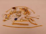 un tas de bijoux en or posé sur une surface blanche