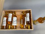 several bottles of alcohol are in a wooden box on a table
