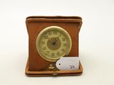 une petite horloge avec une étiquette, posée sur une table