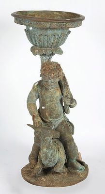 a statue of a man sitting on a rock with a bowl on his head