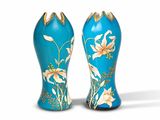 une paire de vases bleus et dorés ornés de fleurs sur fond blanc