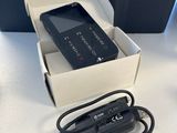 un téléphone portable noir dans une boîte blanche avec un chargeur