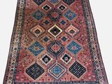 an antique persian rug with a geometric design
