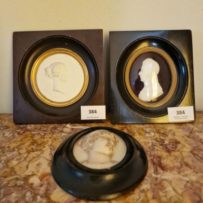 deux photos encadrées représentant un homme et une femme de profil, posées sur une table en marbre