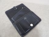 black leather ipad case with a silver button on top of it