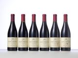 six bottles of red wine lined up in a row