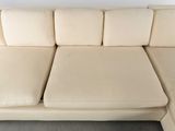 beige leather sectional sofa with chaise and pillows in a living room