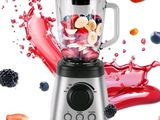 un mixeur contenant des fruits et des baies, sur un fond blanc