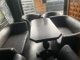 a black leather couch and a table in the corner of a room