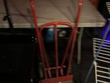 a table with a chair and a rack with brooms on it
