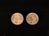 une paire de deux pièces d'or posées sur une surface noire