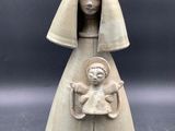 an image of a statue of a woman holding a baby in her arms