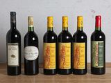 plusieurs bouteilles de vin sont alignées sur une table en bois