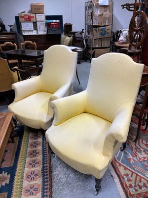 une paire de fauteuils rembourrés jaunes dans une pièce où se trouve un tapis