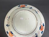 an image of a white plate with blue and orange flowers on it